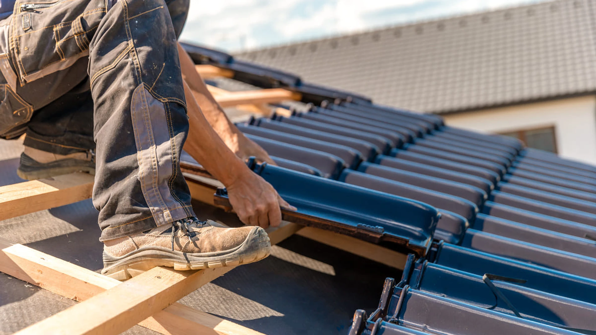 Pose de tuiles sur la toiture d’une maison