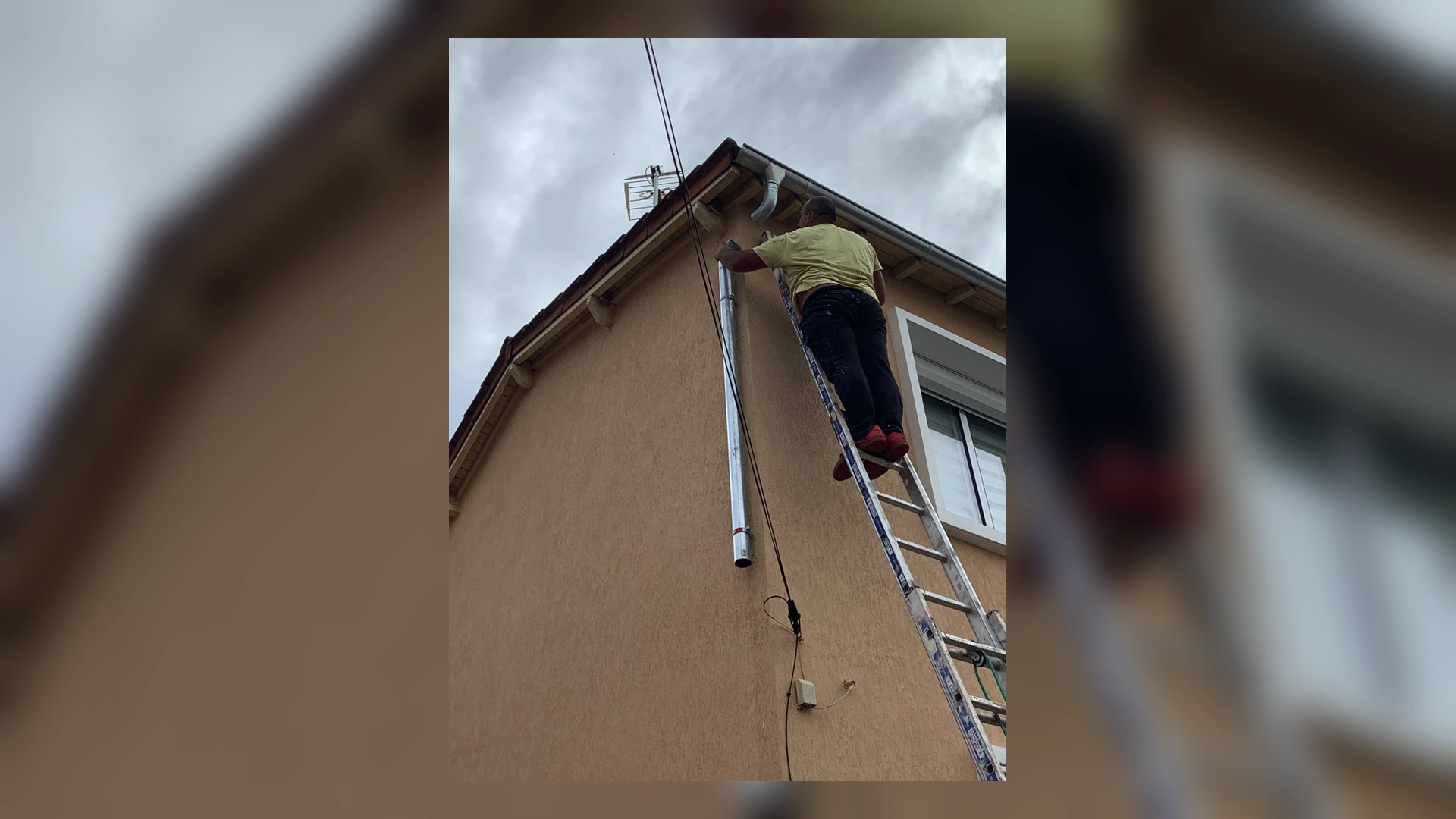 Pose d’une descente d’eau pluviale sur une maison
