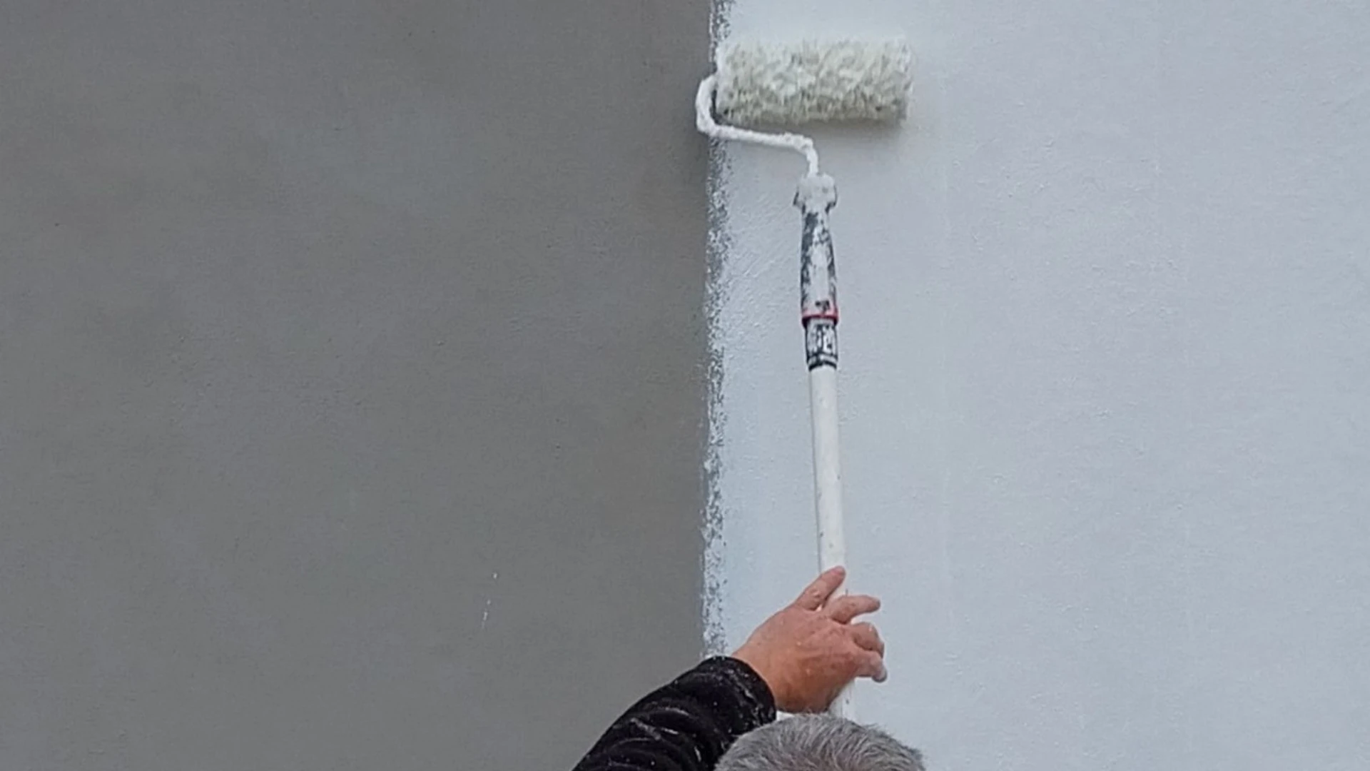 Application de peinture au rouleau sur une façade extérieure
