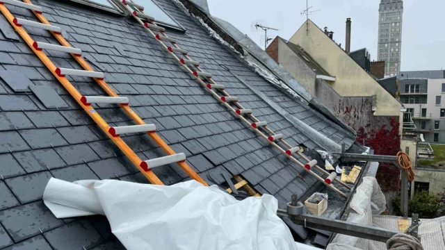 Intervention sur une toiture en ardoise avec des échelles de couvreur